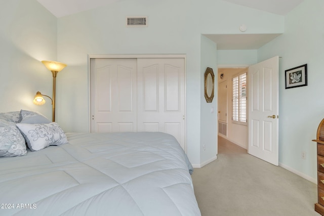 bedroom featuring lofted ceiling, light carpet, and a closet