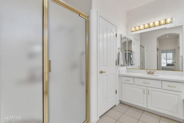 bathroom featuring a shower with door, tile patterned flooring, and vanity