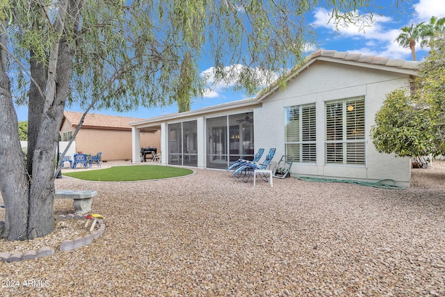 back of property featuring a sunroom and a patio area