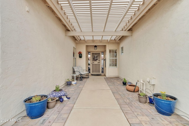 property entrance featuring a patio area and a pergola