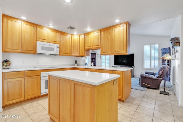 kitchen with white appliances, light tile patterned floors, lofted ceiling, and kitchen peninsula