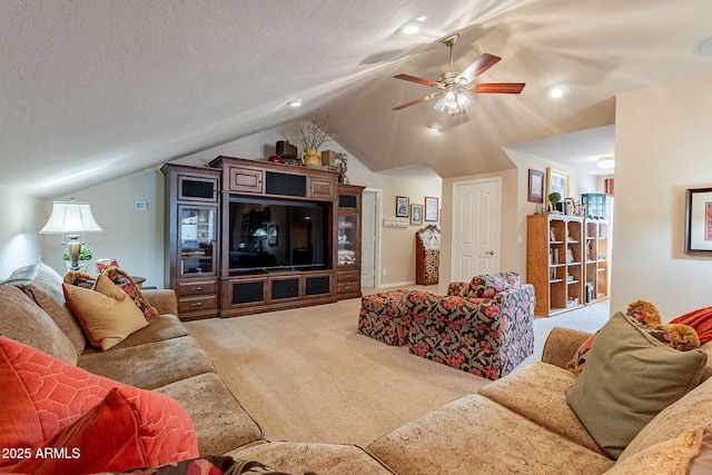 living room featuring ceiling fan, lofted ceiling, carpet floors, and a textured ceiling