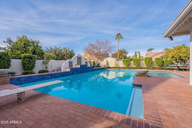 view of pool featuring a diving board and a patio