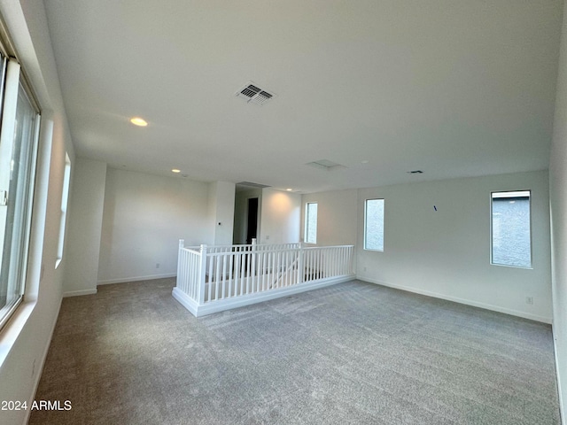 carpeted spare room featuring a healthy amount of sunlight