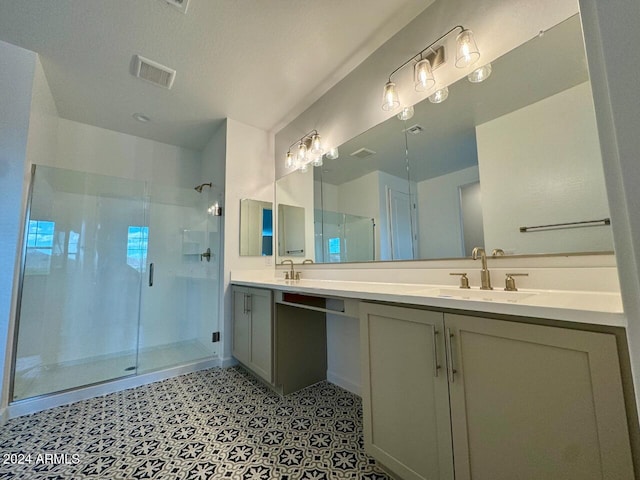 bathroom with vanity, a shower with shower door, and a textured ceiling