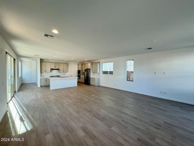 unfurnished living room featuring hardwood / wood-style floors and sink