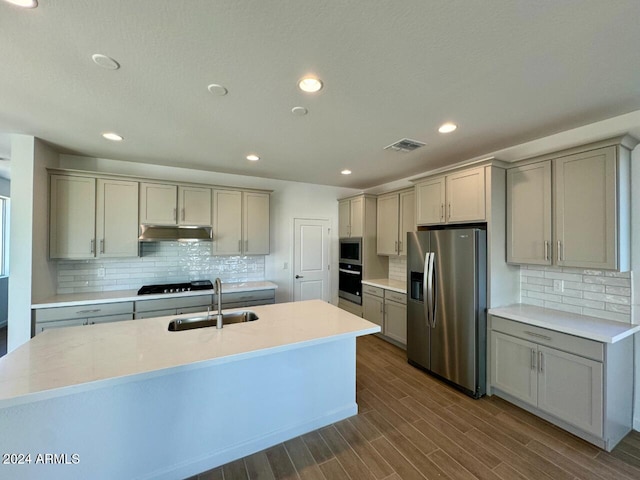 kitchen with gray cabinetry, backsplash, sink, dark hardwood / wood-style floors, and appliances with stainless steel finishes