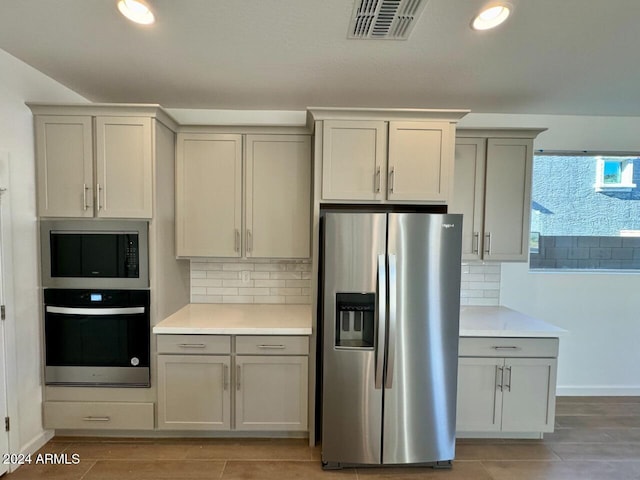 kitchen featuring stainless steel refrigerator with ice dispenser and backsplash