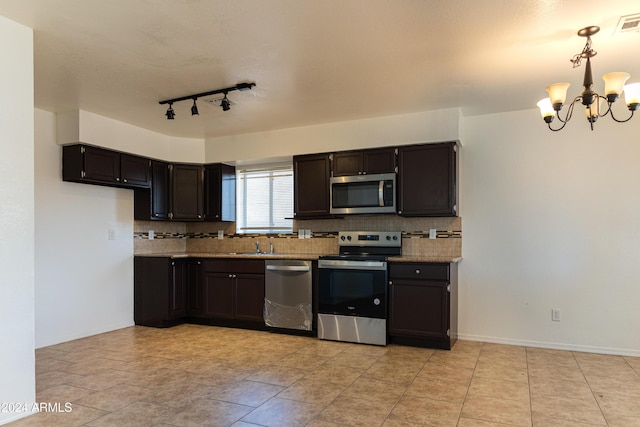 kitchen featuring light stone countertops, tasteful backsplash, stainless steel appliances, pendant lighting, and a notable chandelier