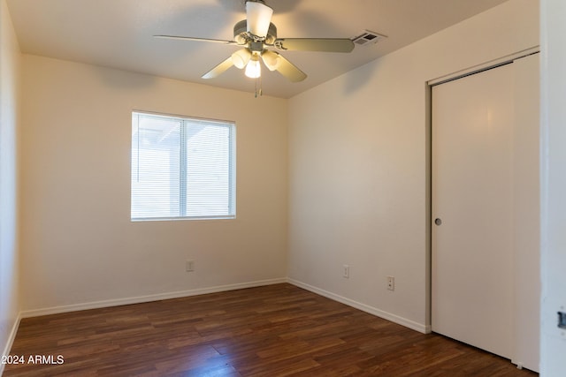 empty room with dark hardwood / wood-style floors and ceiling fan