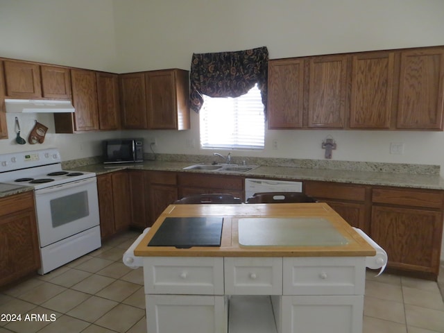 kitchen featuring white cabinetry, sink, light tile patterned floors, and white appliances