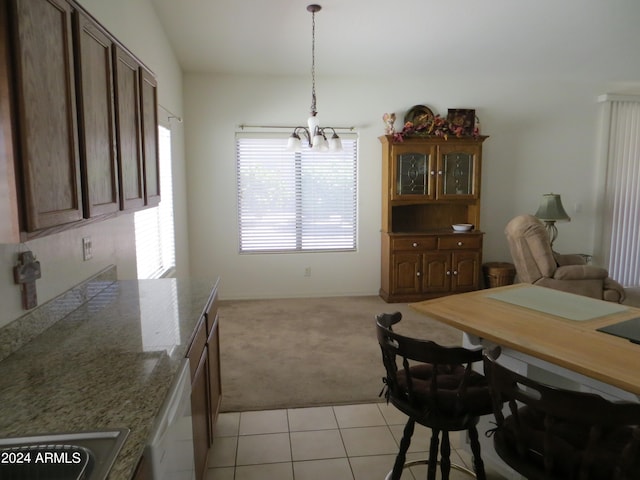 dining room with an inviting chandelier, light colored carpet, and vaulted ceiling