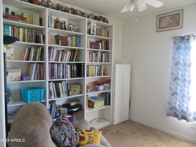 living area featuring light carpet and ceiling fan