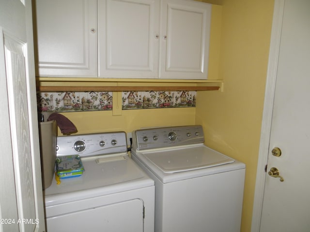 clothes washing area featuring independent washer and dryer and cabinets