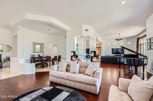 living room with ceiling fan with notable chandelier