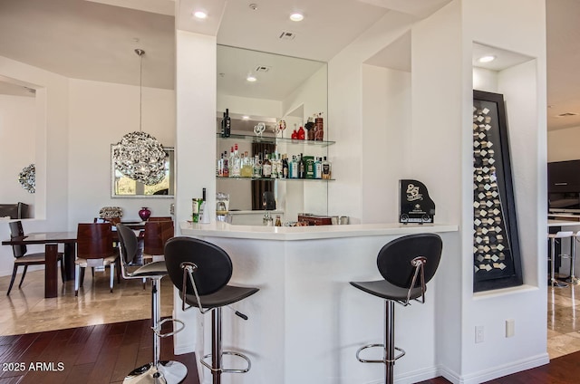 bar with pendant lighting, dark hardwood / wood-style floors, and white cabinetry