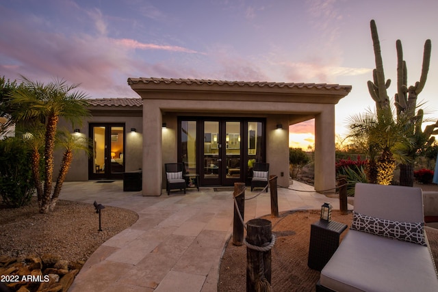 patio terrace at dusk featuring french doors