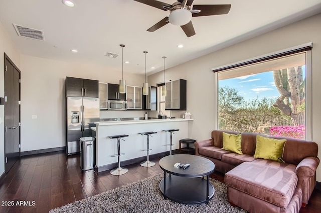 living room with ceiling fan and dark hardwood / wood-style flooring