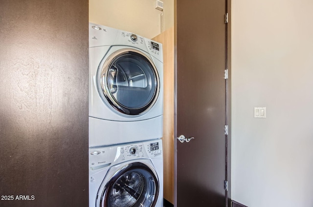 laundry area featuring stacked washer / drying machine