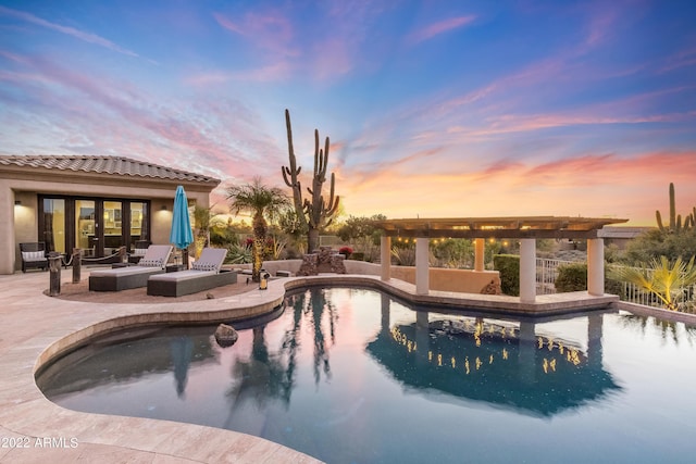 pool at dusk with a patio area