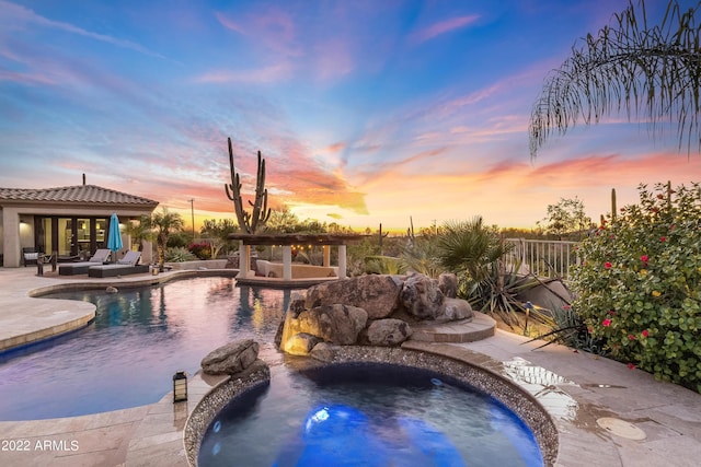 pool at dusk featuring a patio and a hot tub