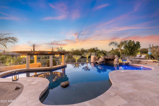 pool at dusk featuring a patio area