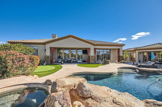 view of swimming pool with a patio and a hot tub