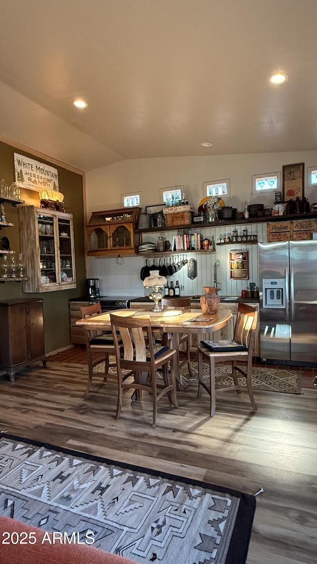 dining room with vaulted ceiling, recessed lighting, and wood finished floors