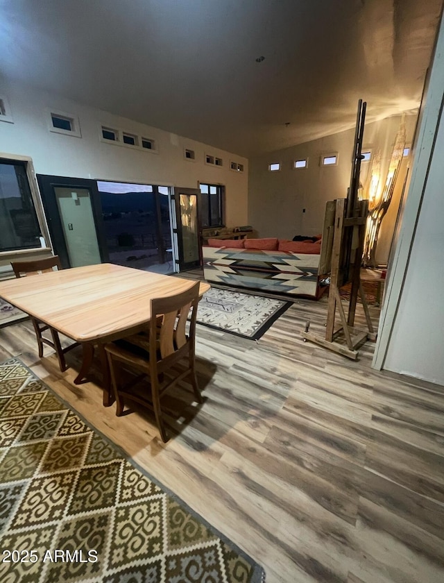 dining room featuring vaulted ceiling, wood finished floors, and visible vents