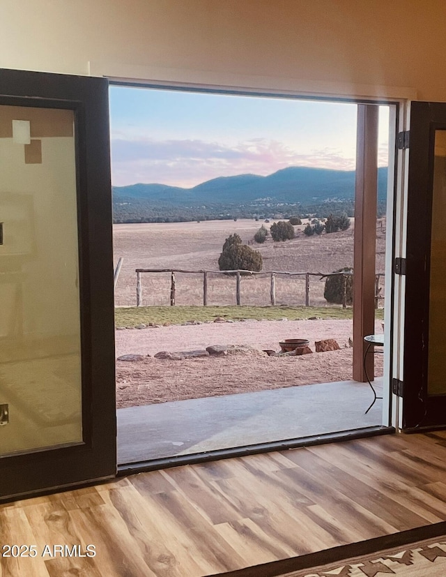 doorway with a mountain view and wood finished floors