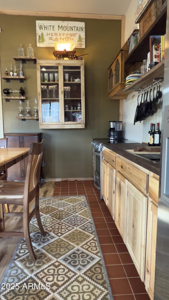 kitchen featuring dark countertops, open shelves, dark tile patterned floors, and stainless steel electric range oven