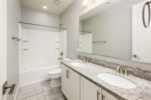 bathroom featuring visible vents, a sink, toilet, and tub / shower combination