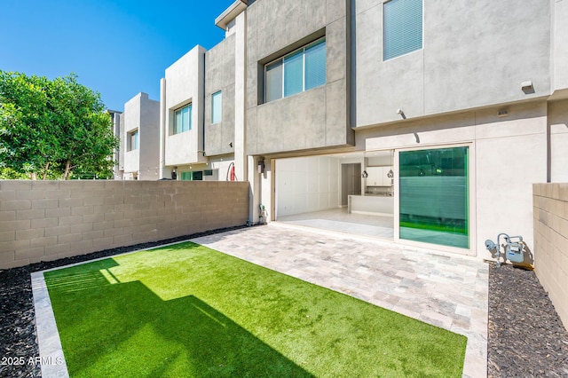 exterior space featuring a patio, stucco siding, fence, and a lawn