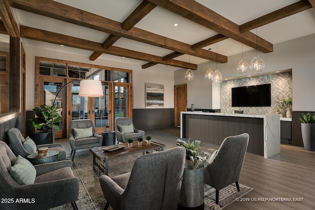 living room with beamed ceiling, wainscoting, and wood finished floors