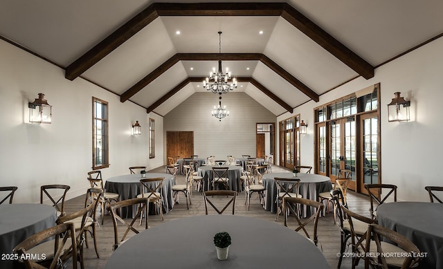 dining space featuring beamed ceiling, high vaulted ceiling, a notable chandelier, and wood finished floors