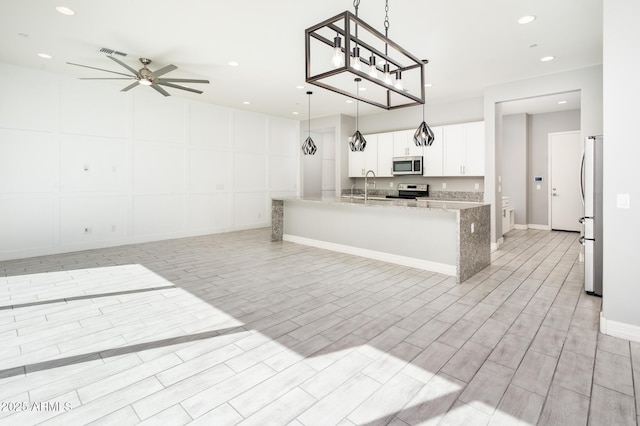 kitchen with visible vents, open floor plan, ceiling fan, appliances with stainless steel finishes, and white cabinetry