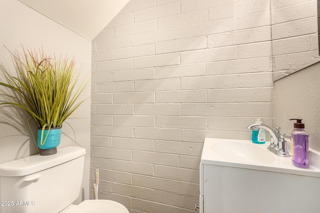 8532 E Portland St, Scottsdale, AZ 85257 - bathroom with vanity, lofted ceiling, and brick wall