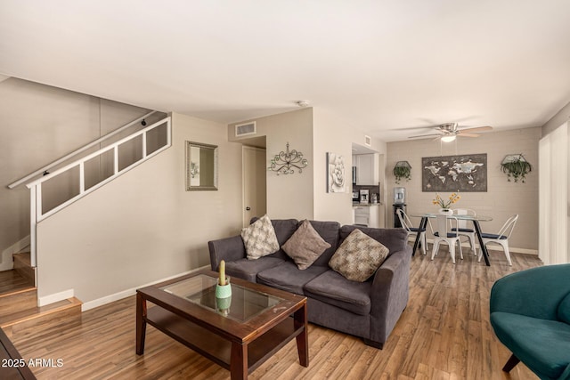 8532 E Portland St, Scottsdale, AZ 85257 - living room featuring stairway, light wood-style floors, and a ceiling fan