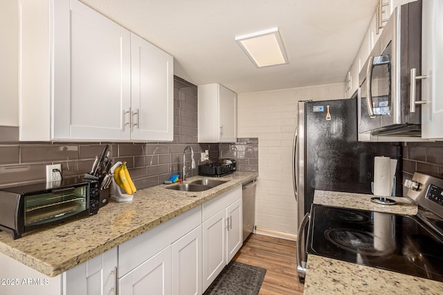 8532 E Portland St, Scottsdale, AZ 85257 - kitchen featuring stainless steel appliances, white cabinets, light wood finished floors, and light stone countertops