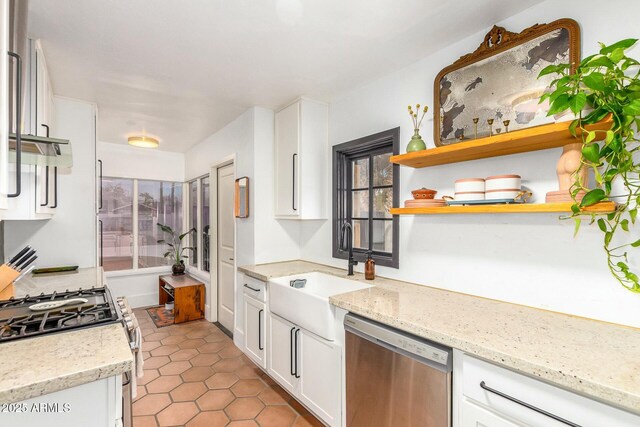 kitchen with stainless steel appliances, light stone countertops, sink, and white cabinets