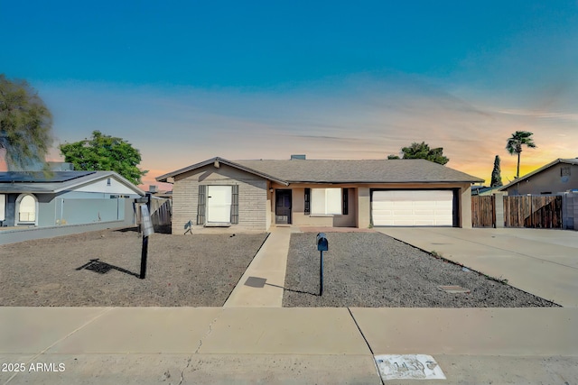 ranch-style house with brick siding, fence, driveway, and an attached garage