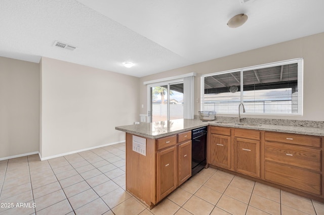 kitchen with a sink, light tile patterned floors, visible vents, and dishwasher