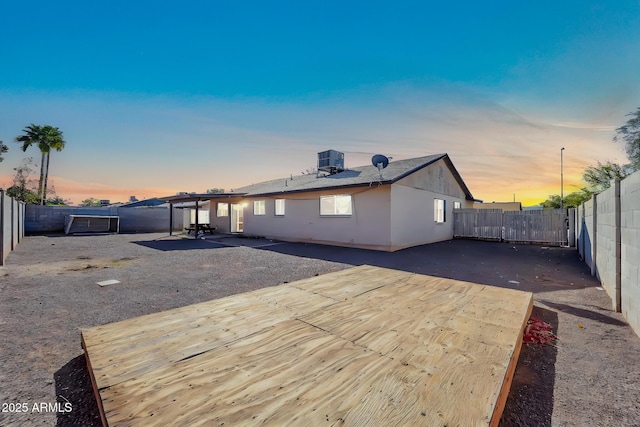 back of house with a patio area, a fenced backyard, central AC unit, and stucco siding