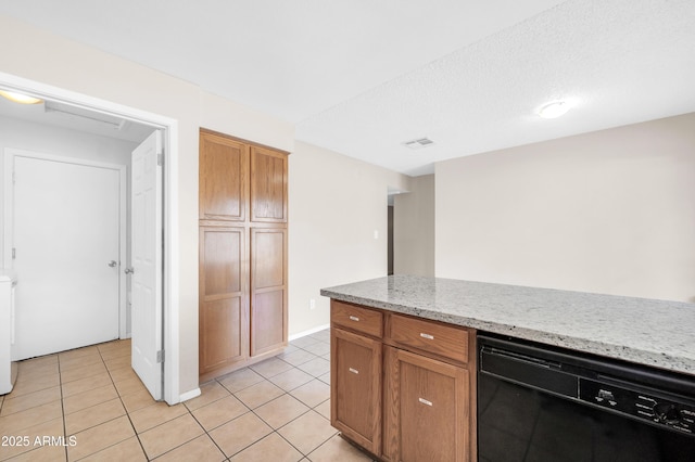 kitchen featuring light stone counters, black dishwasher, light tile patterned floors, visible vents, and brown cabinetry