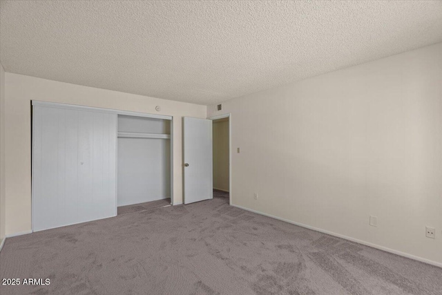 unfurnished bedroom featuring carpet flooring, a closet, and a textured ceiling