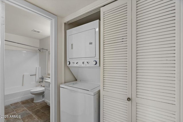 laundry area featuring stacked washer and clothes dryer