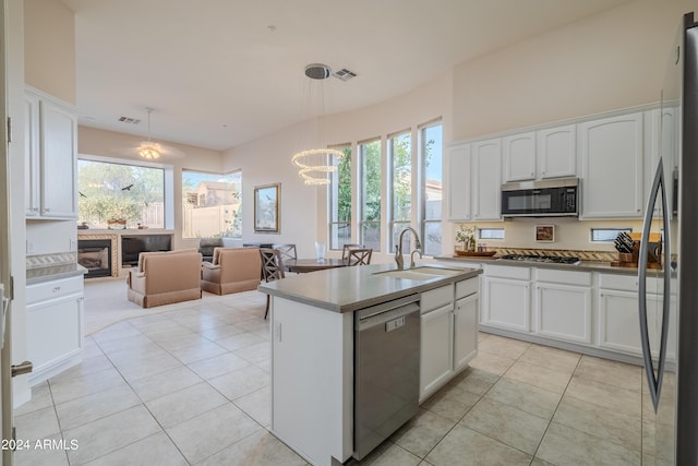 kitchen featuring stainless steel appliances, pendant lighting, white cabinets, and sink