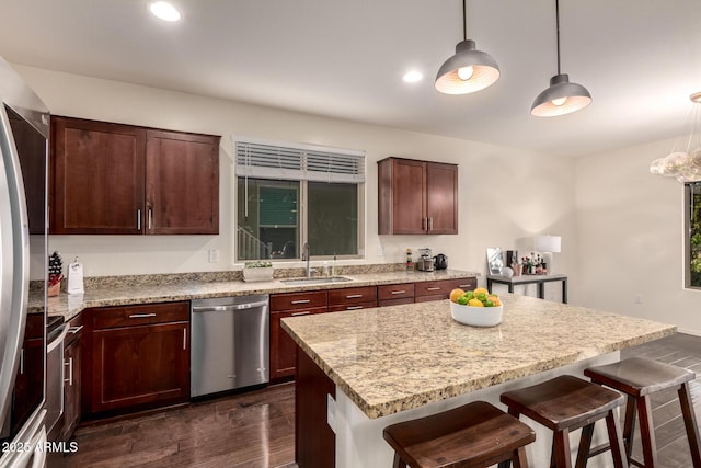 2149 E Aire Libre Ave, Phoenix, AZ 85022 - kitchen with appliances with stainless steel finishes, a kitchen breakfast bar, dark wood-style floors, hanging light fixtures, and a center island