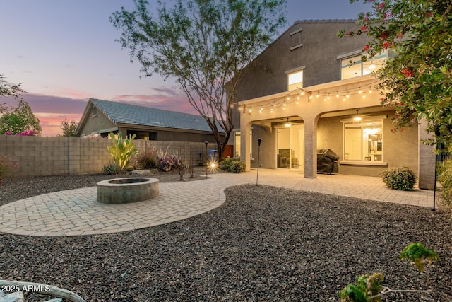 2149 E Aire Libre Ave, Phoenix, AZ 85022 - back of house at dusk featuring an outdoor fire pit, stucco siding, and a patio