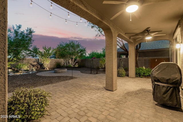 2149 E Aire Libre Ave, Phoenix, AZ 85022 - patio terrace at dusk featuring ceiling fan, a fenced backyard, a patio area, and a fire pit